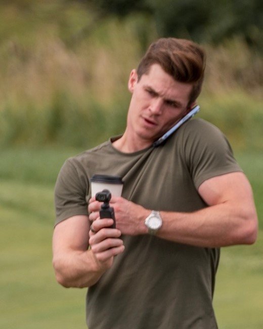 Jake Spotswood filming content on a phone call at a charity golf event